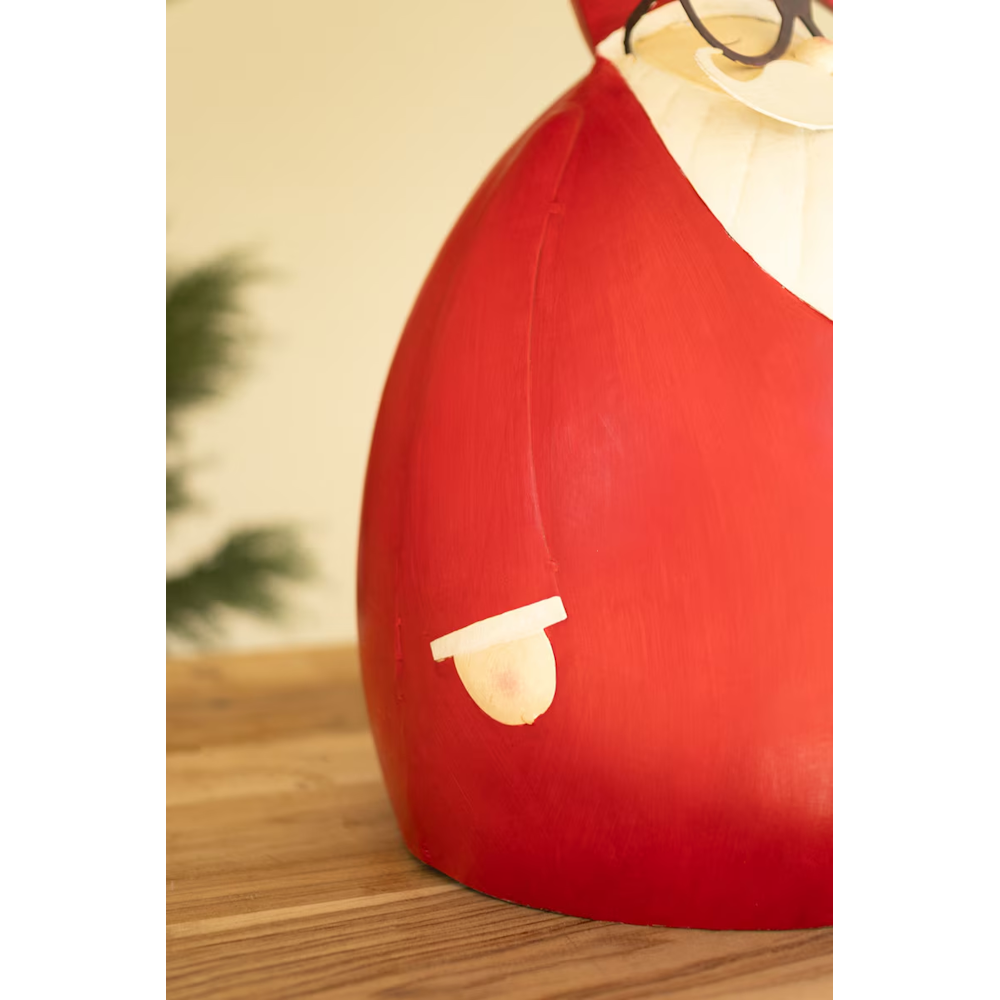 Close-up view of a red metal Santa sculpture displaying white mitten details on its side.