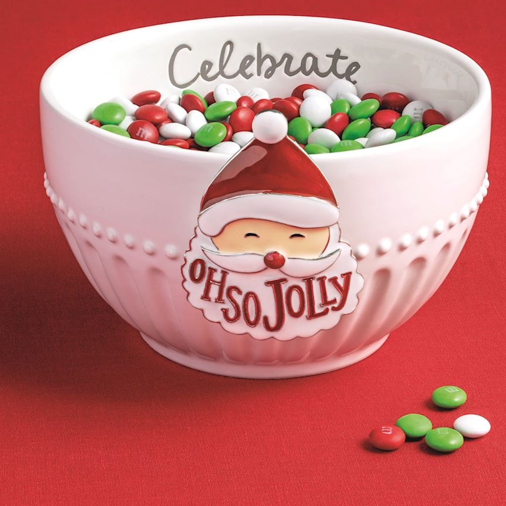 A festive white ceramic bowl filled with Christmas M&Ms, featuring a Santa emblem that reads "Oh So Jolly".