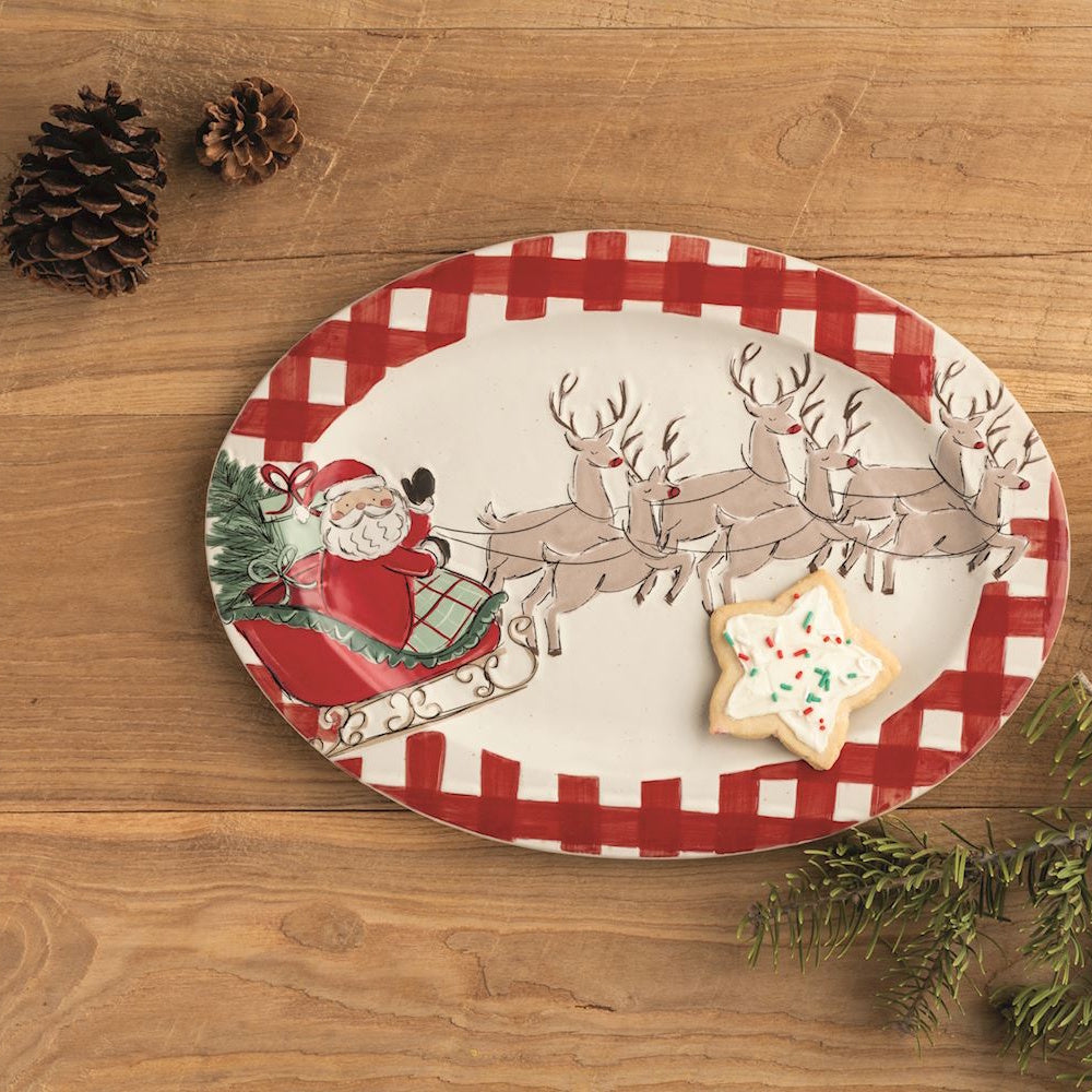 Oval red gingham platter featuring Santa's sleigh, a star cookie, on a rustic wood surface.