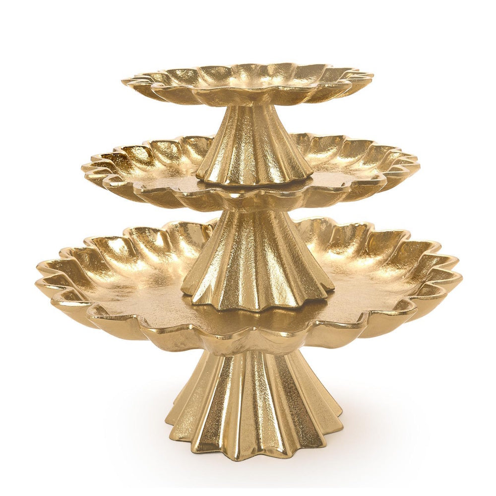 Three-tiered gold cake stand with textured scalloped trays and fluted pedestal bases on a white background.