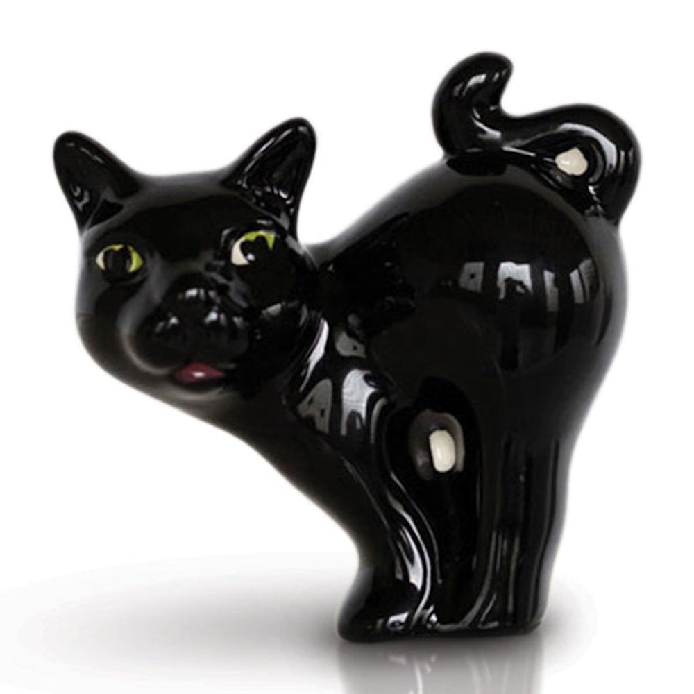 A glossy black ceramic cat figurine in a scaredy-cat pose with an arched back and green eyes.