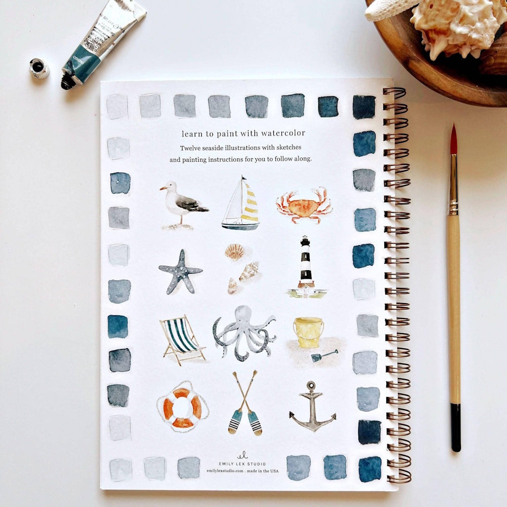 Seaside Watercolor Workbook by Emily Lex Studio featuring 12 beach illustrations, paintbrush, and paint tube.