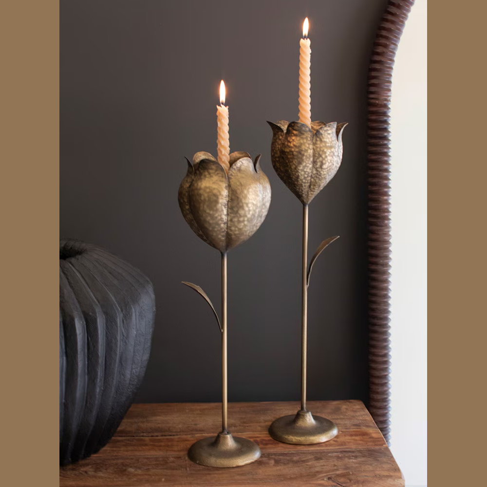 Set of 2 antique brass tulip taper candle holders with hammered texture on a wooden surface.