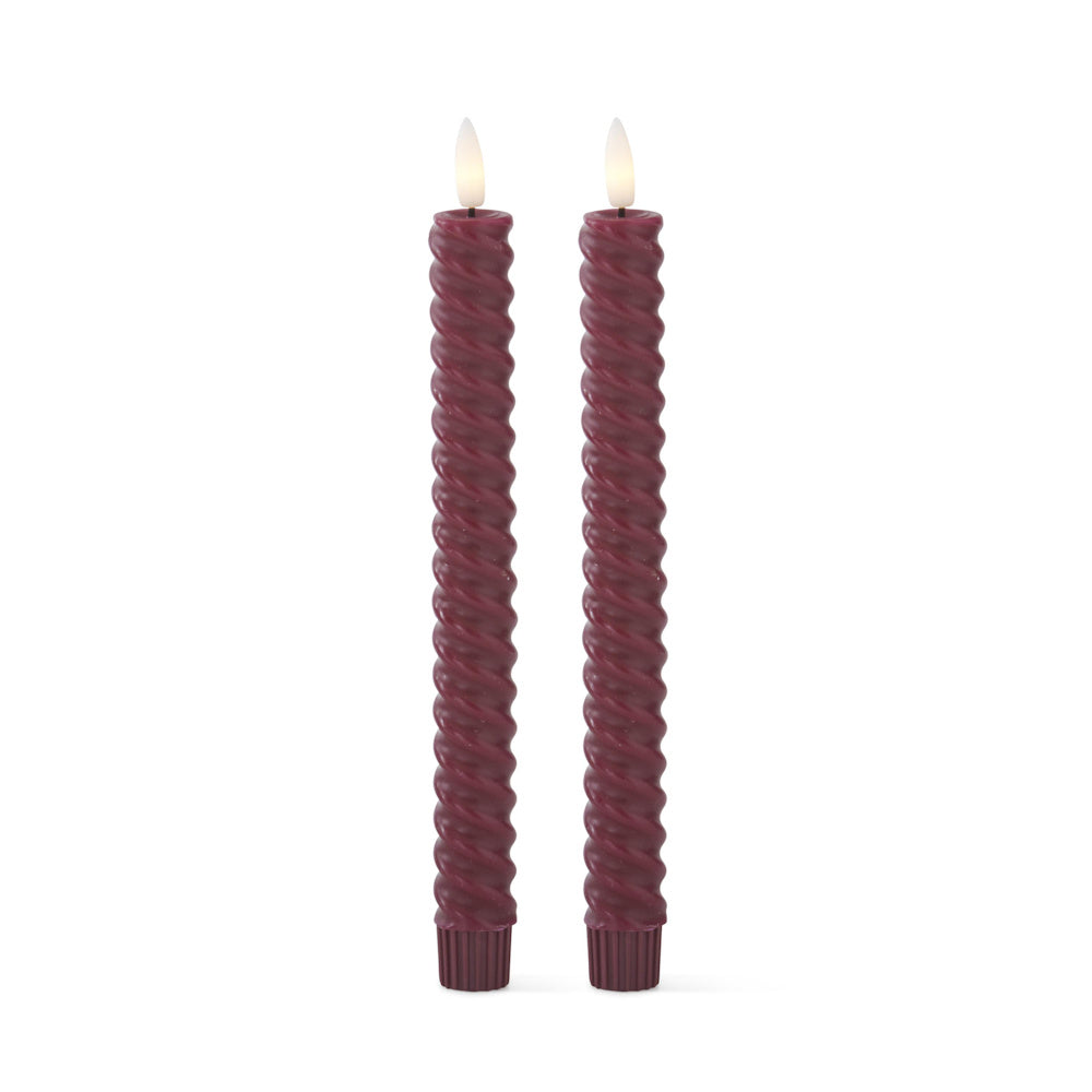 Two burgundy spiral-twisted flameless taper candles with glowing faux flames on a white background.