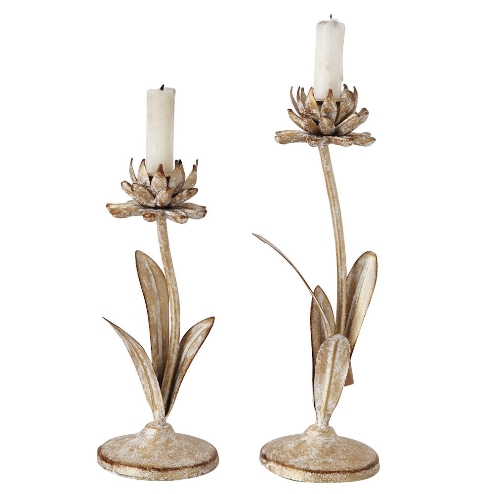 Pair of gold-finished, flower-shaped metal taper candle holders with slender stems, leaves, and round bases.