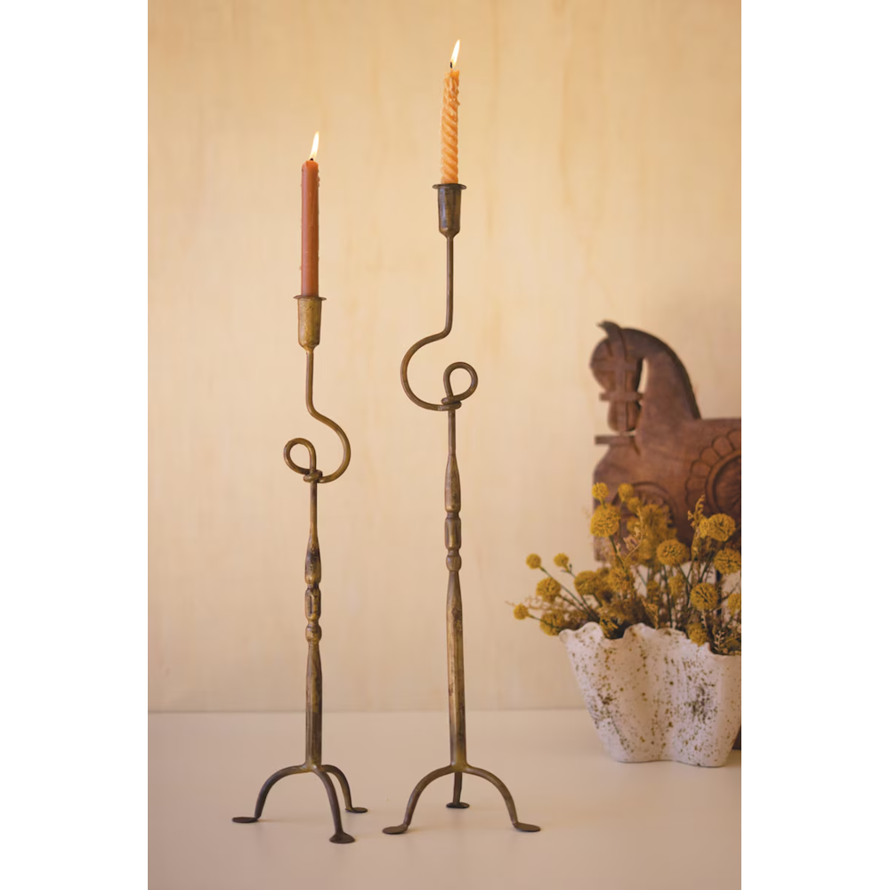 Pair of tall antique brass forged iron taper candleholders with decorative loop accents.