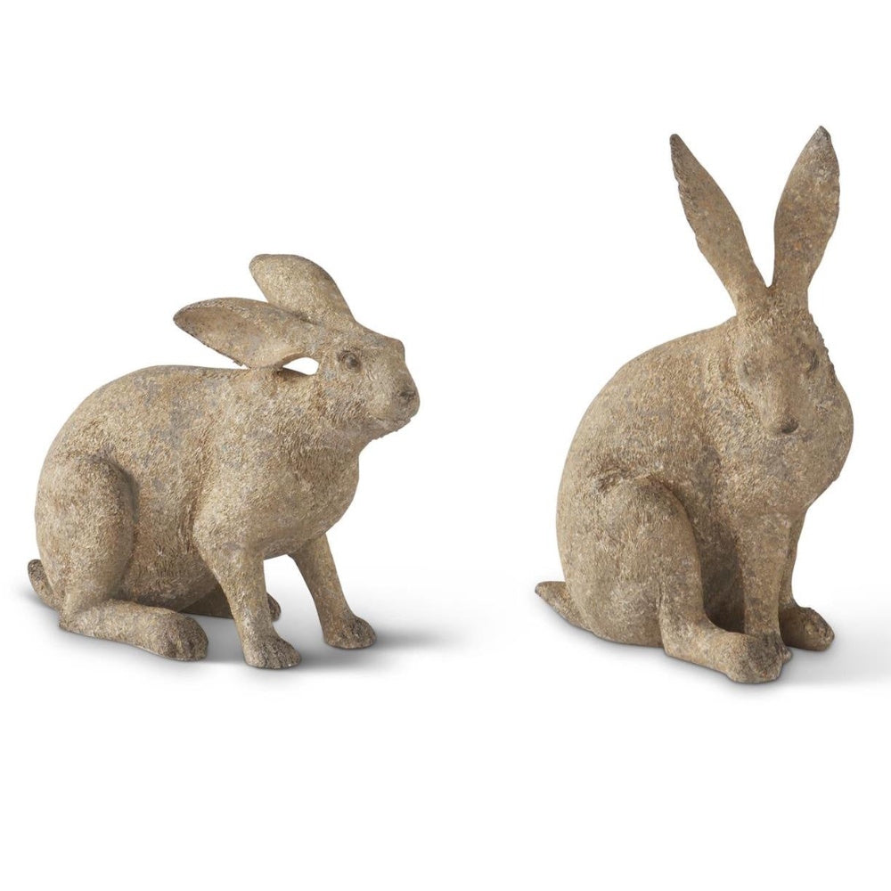 Two rustic, textured stone rabbit statues sitting against a white background.
