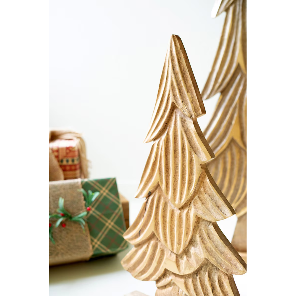 Close-up of a carved natural mango wood Christmas tree with gold accents.