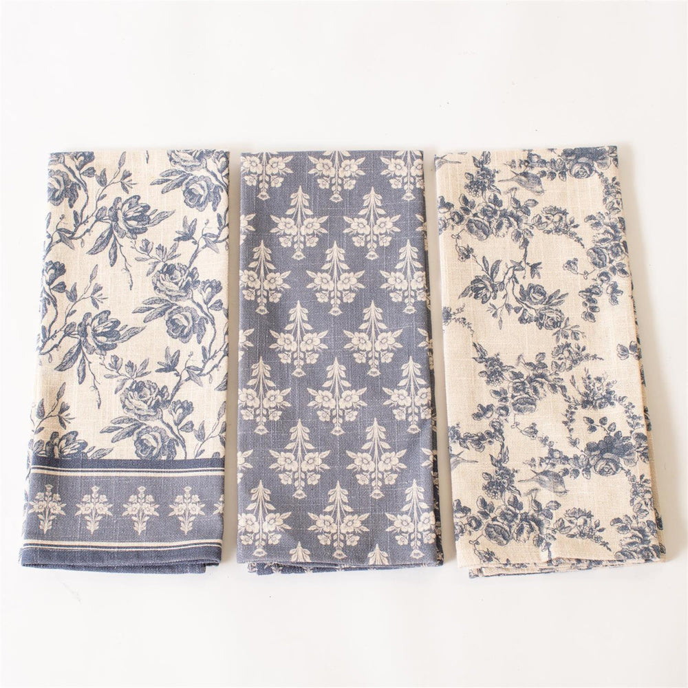 Set of 3 French blue tea towels with vintage floral and toile patterns on cream linen for kitchen decor.