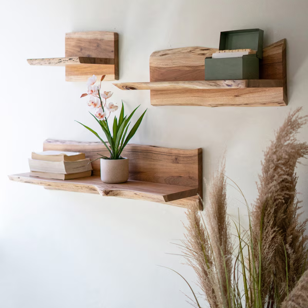 Set of three live-edge wooden floating shelves mounted on a wall with decor items.