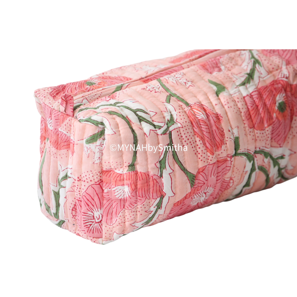 Quilted peach zipper pouch with a pink and green block print floral poppy pattern.
