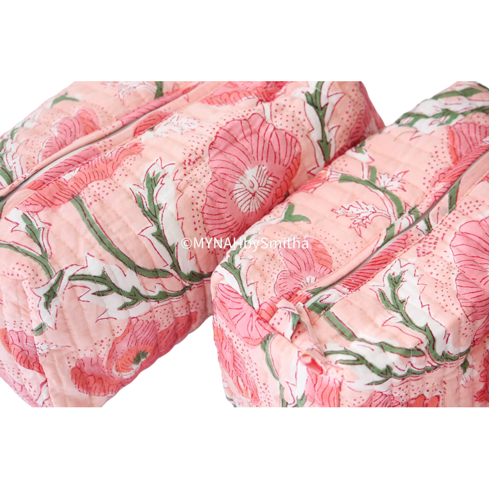 Two peach quilted zipper pouches with a pink poppy floral print and green leaves on a white background.
