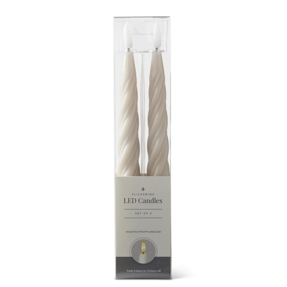 A set of two cream-colored spiral LED taper candles in clear packaging.