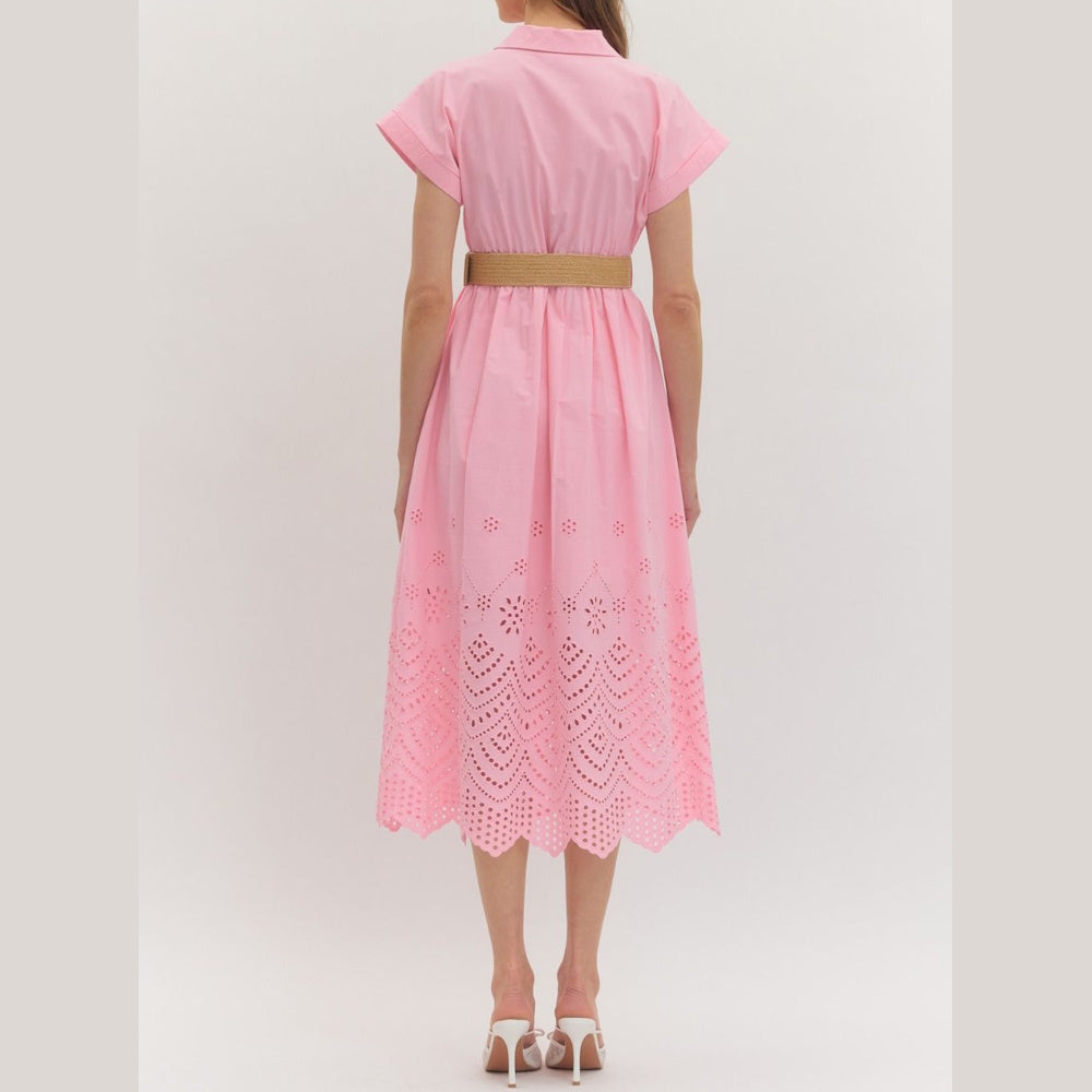 Back view of a pink midi shirt dress with eyelet lace hem, short cuffed sleeves, and a beige woven belt.