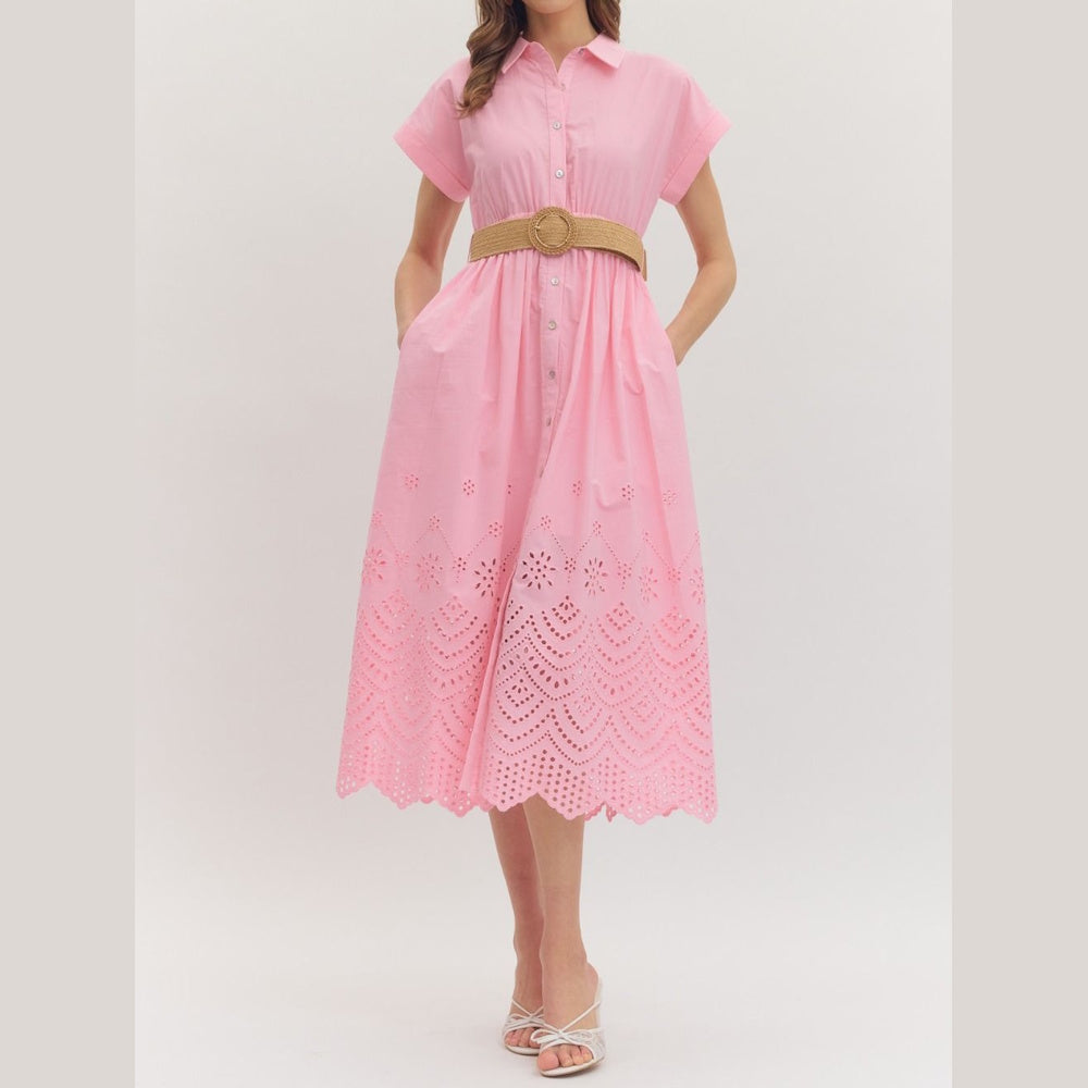 Pink eyelet midi shirtdress with short cuffed sleeves, a button-down front, and a woven straw belt.
