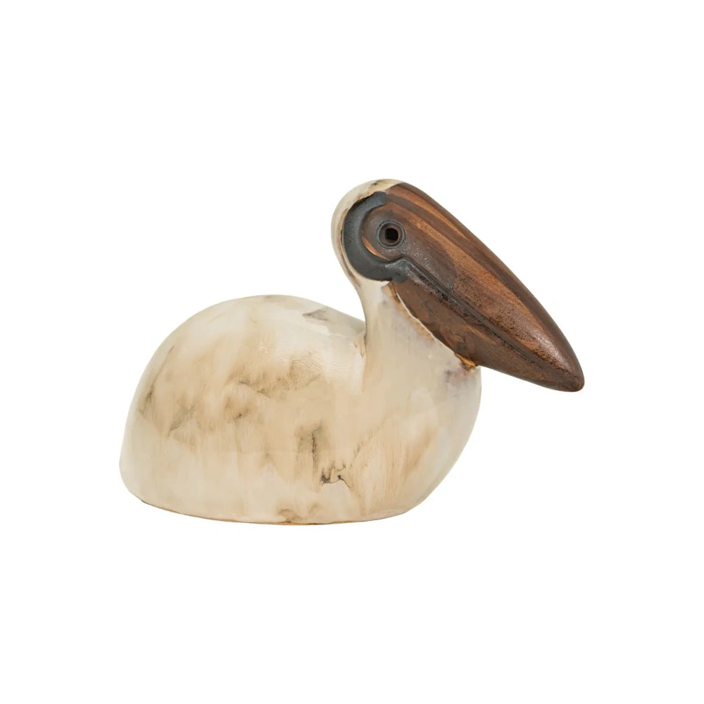 Side profile of a ceramic pelican sculpture with a beige glazed body and a large brown beak.