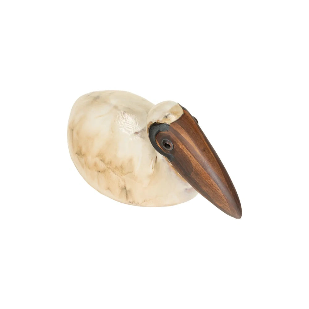 Top view of a smooth, cream-colored pelican sculpture featuring a large, dark wooden beak.
