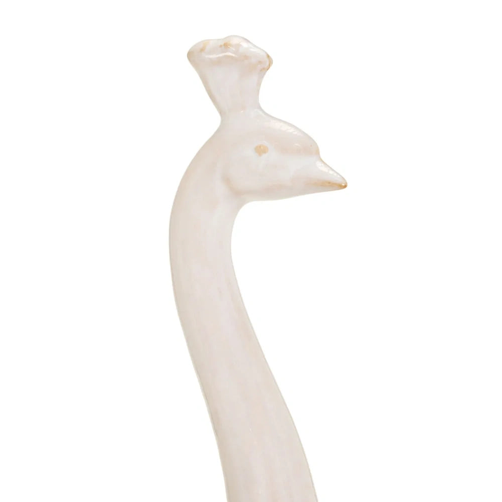 Close-up of an elegant, off-white peacock head sculpture with a slender neck and crown crest.