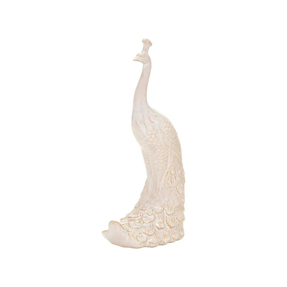 Side view of an elegant, cream-colored peacock sculpture with intricate feather details and a crest.