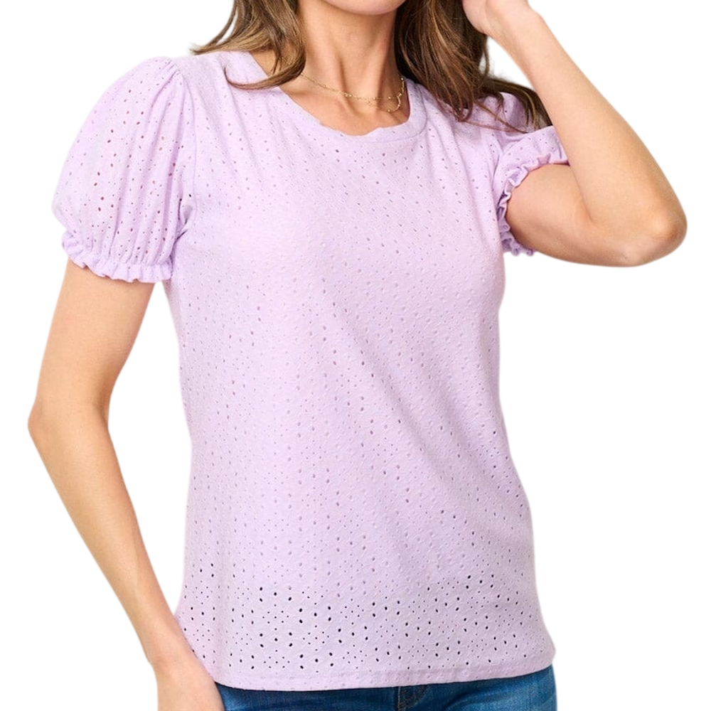 A person wearing a light purple, short-sleeve eyelet blouse with ruffled, puffed sleeves and a crew neck.