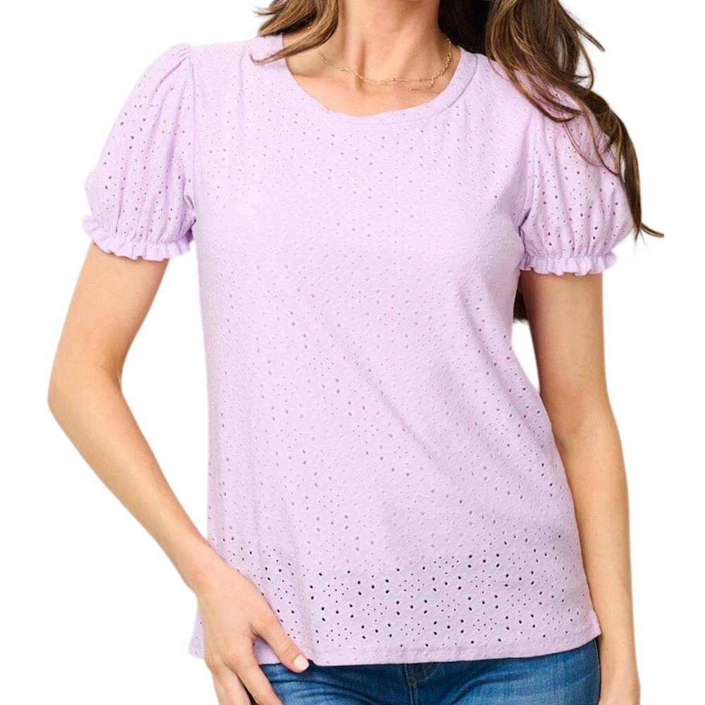 Woman wearing a light purple eyelet blouse with short puff sleeves, paired with blue jeans.