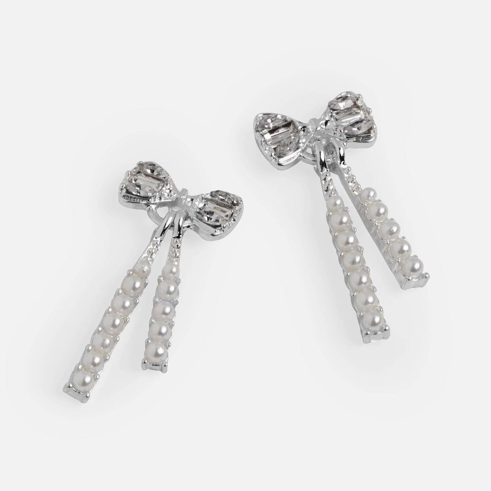 Silver bow dangle earrings with crystal embellishments and hanging white pearl strands.