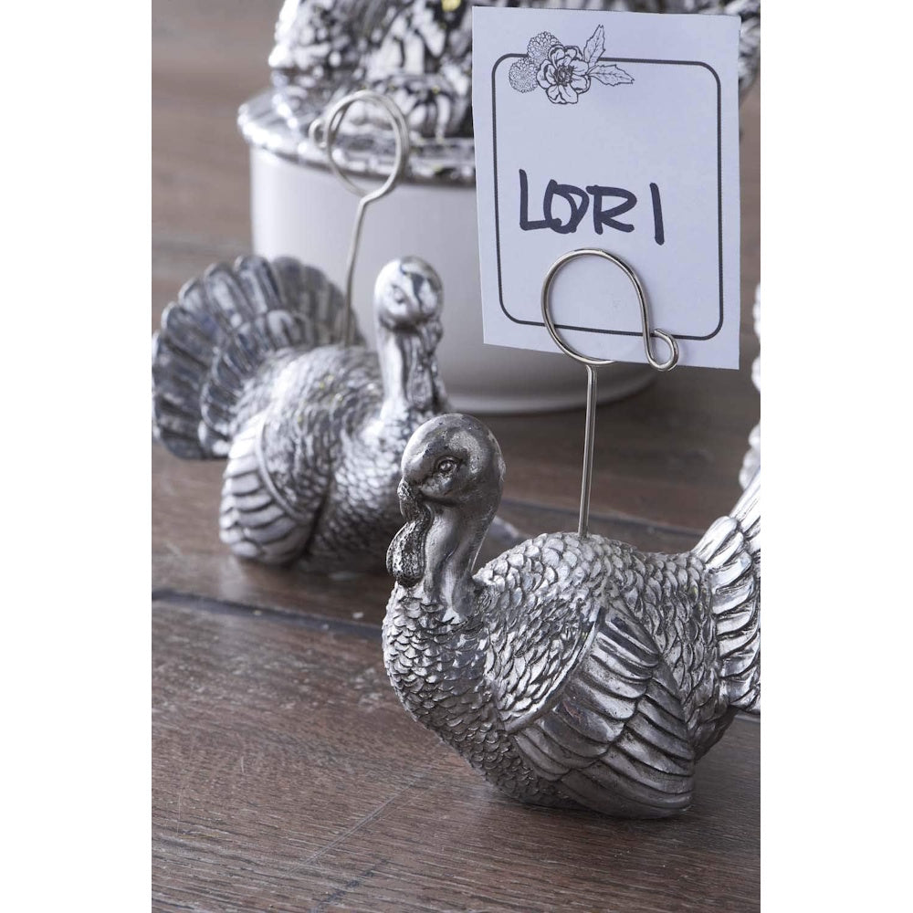 Silver turkey-shaped place card holders with a wire clip displaying a name tag.