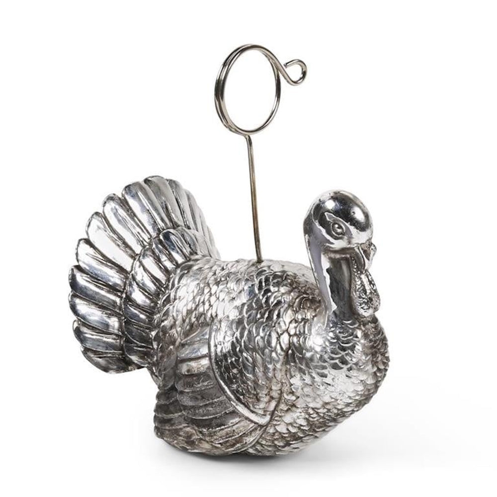 Metallic silver turkey figurine place card holder with a coiled wire loop clip on its back.
