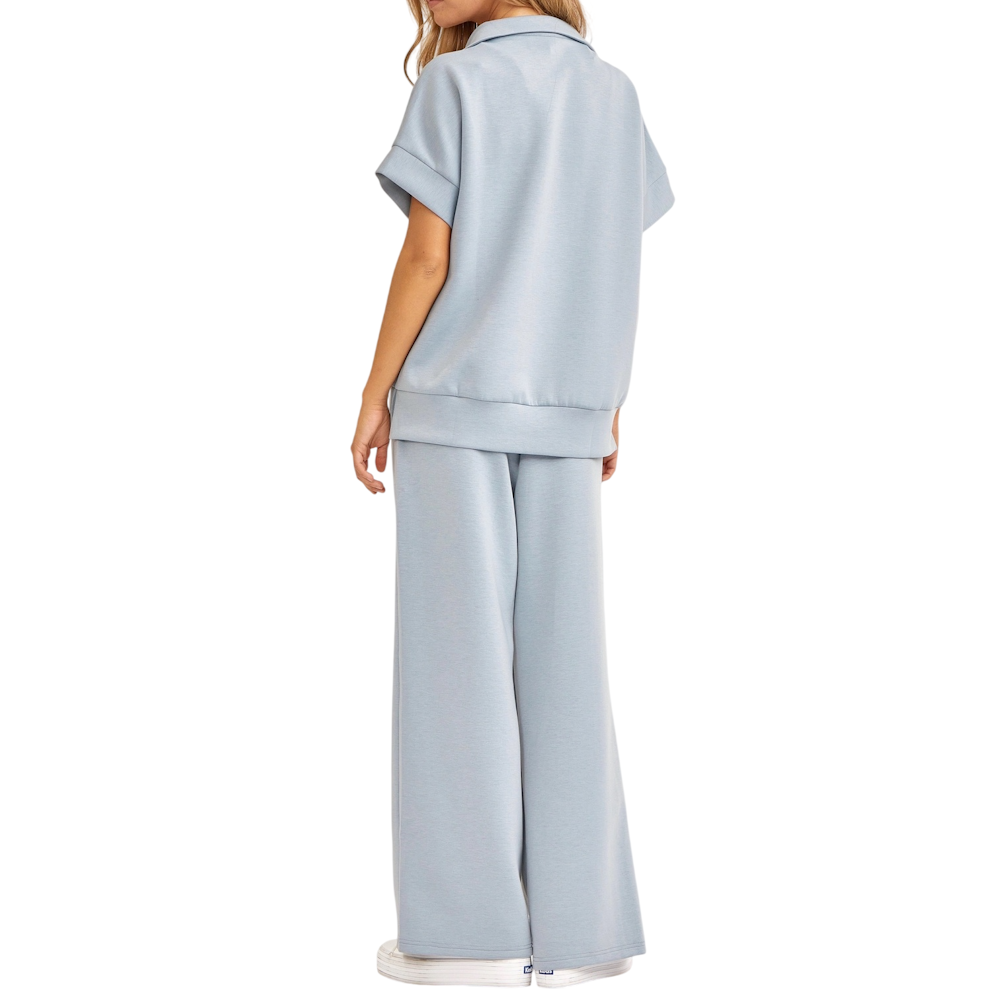 Rear view of a person wearing a light slate blue short-sleeve top and matching wide-leg lounge pants.