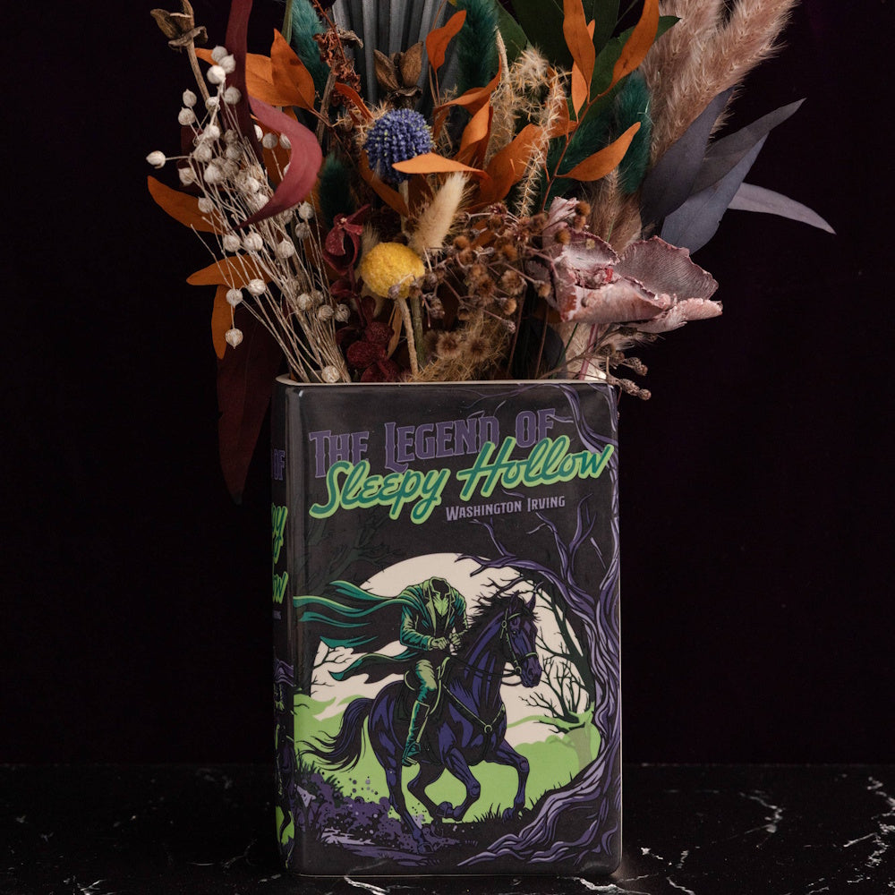 Dark book-shaped vase featuring "The Legend of Sleepy Hollow" cover art filled with dried flowers.