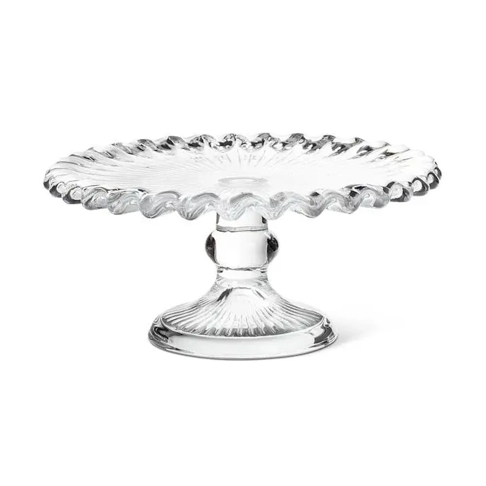 Clear glass cake stand with a ruffled edge and pedestal base.