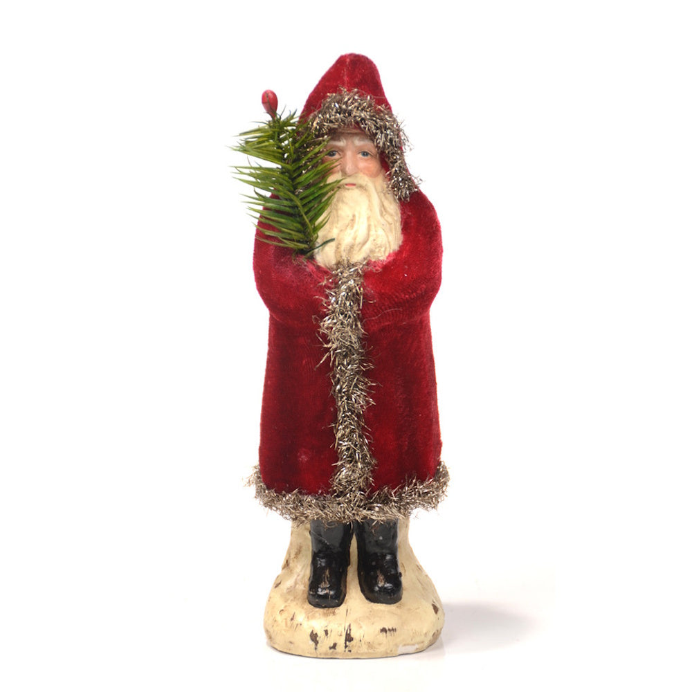 Vintage Belsnickle Santa figure in a red velvet coat with tinsel trim, holding a small evergreen branch.