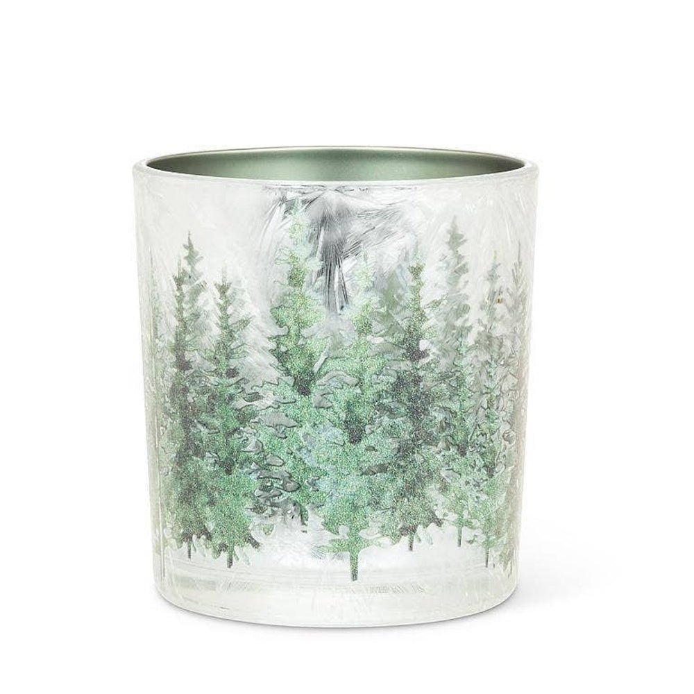 Frosted glass candle holder with a glittery green winter pine tree forest scene, unlit.