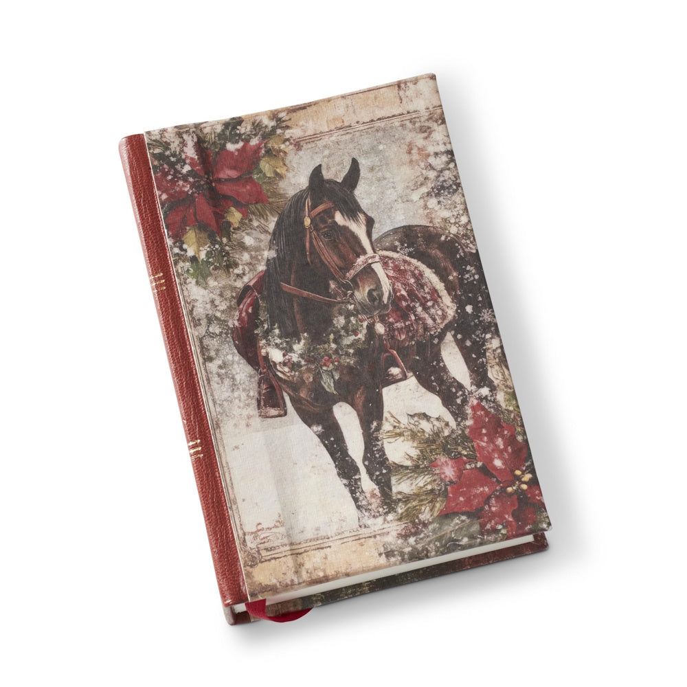 A hardcover journal with a red leather spine and an equestrian Christmas illustration on the cover.