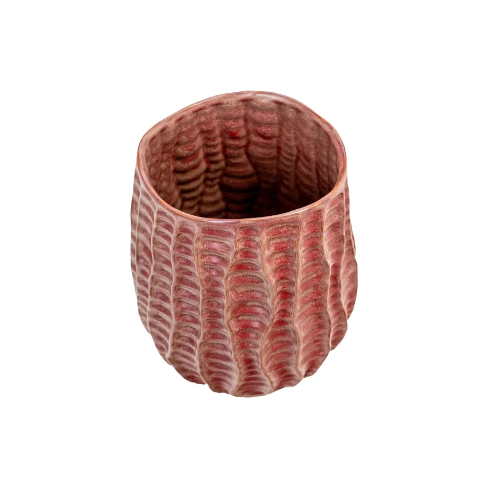 Small, textured reddish-pink ceramic vase with vertical ridges and an organic, slightly asymmetrical opening.