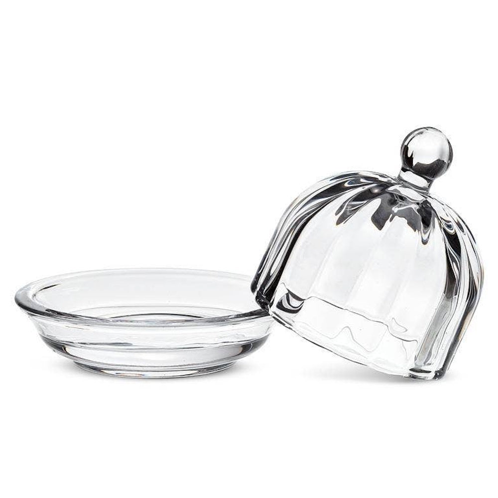 Small round clear glass optic dish with matching domed lid open next to it on a white background.