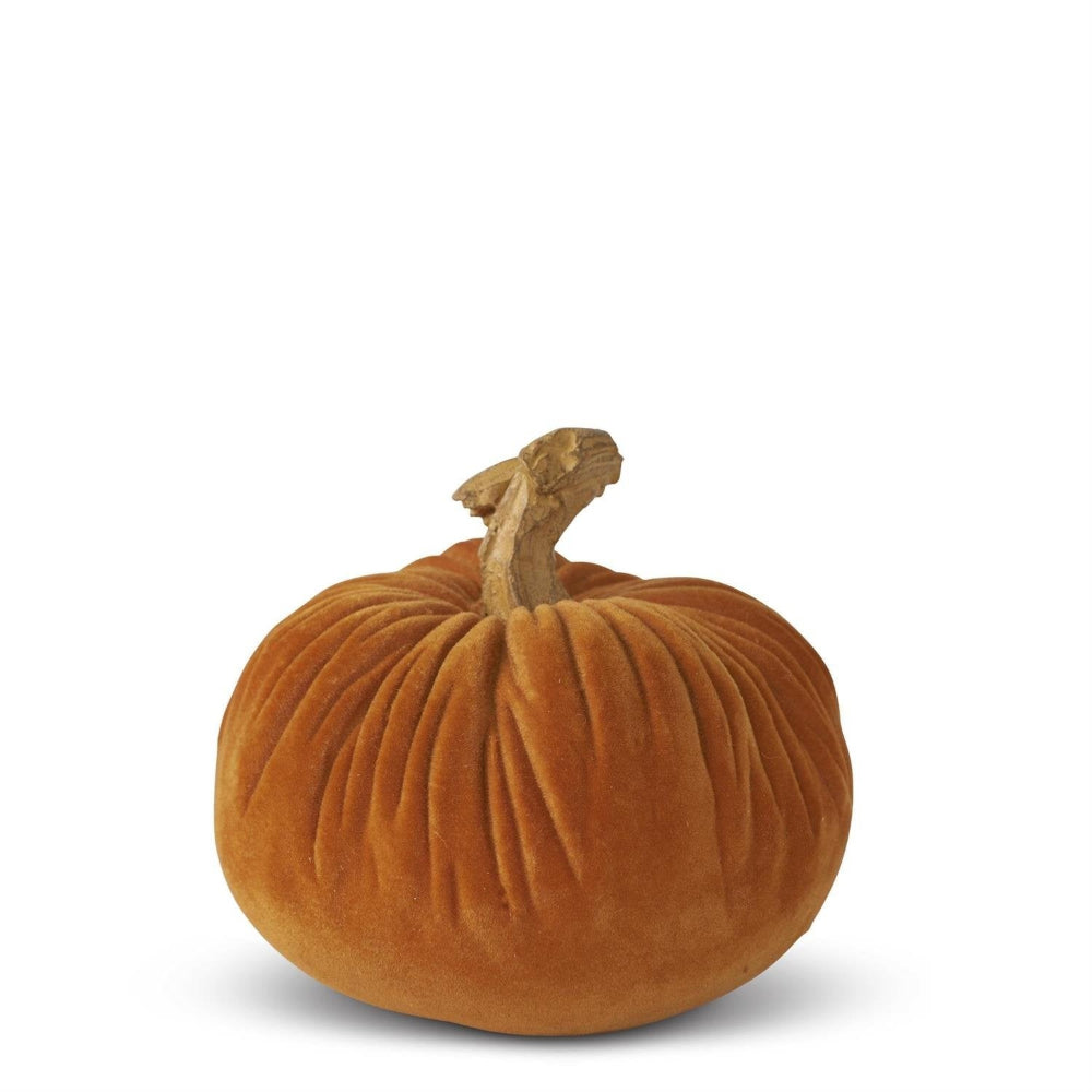 A small, textured orange velvet pumpkin with a realistic brown stem against a solid white background.