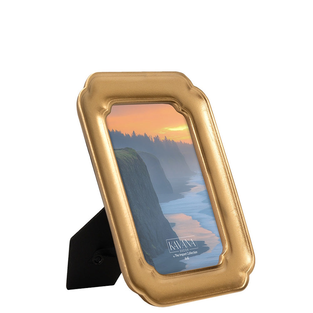 Gold scalloped picture frame with a landscape sunset photo, standing on a white background.