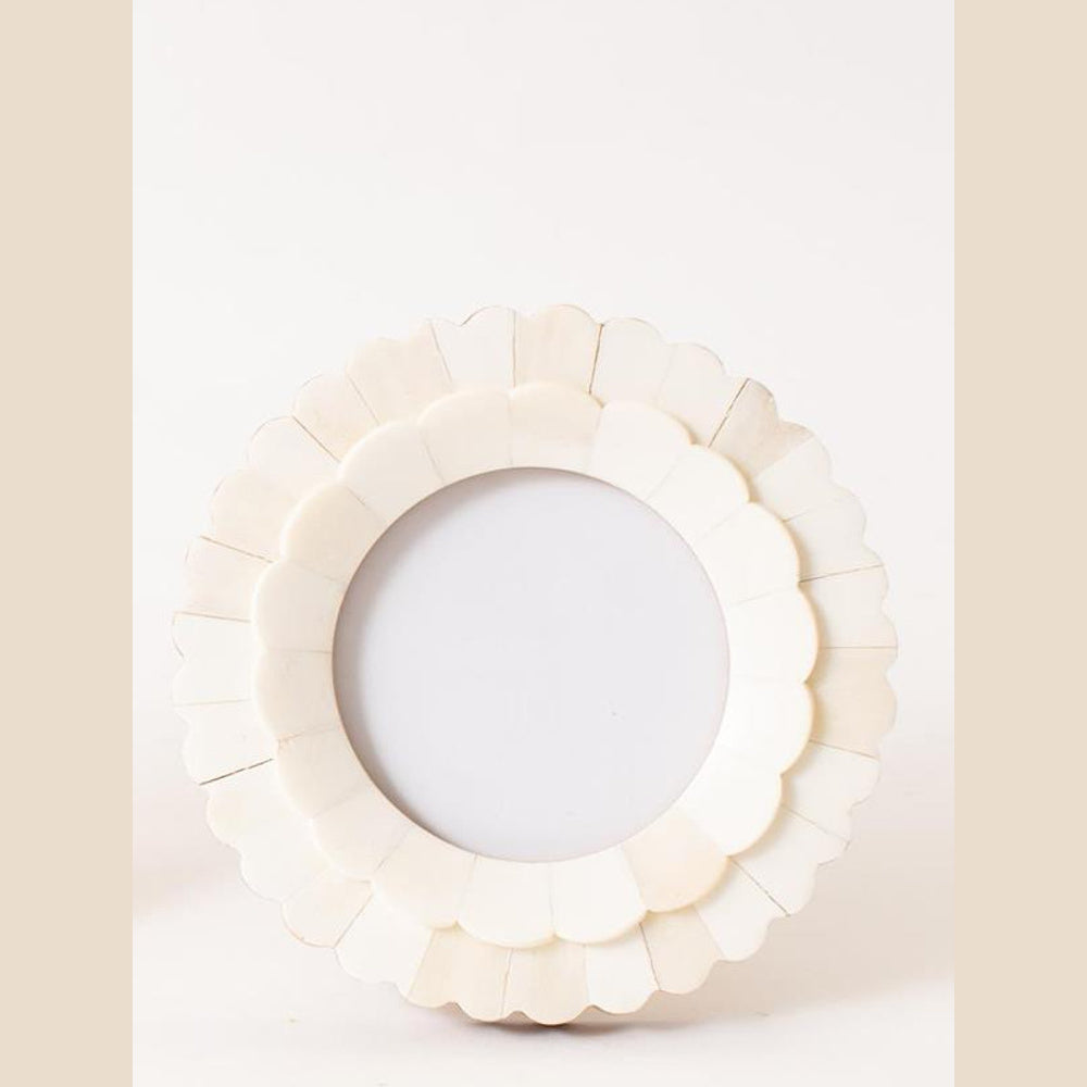 A single round white scalloped bone photo frame with a tiered petal design, shown against a plain background.
