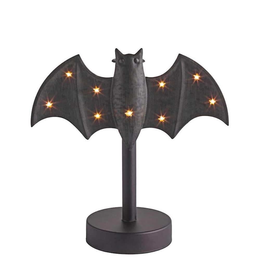 Lit black bat-shaped Halloween decoration with star-shaped LED lights on a pedestal stand.