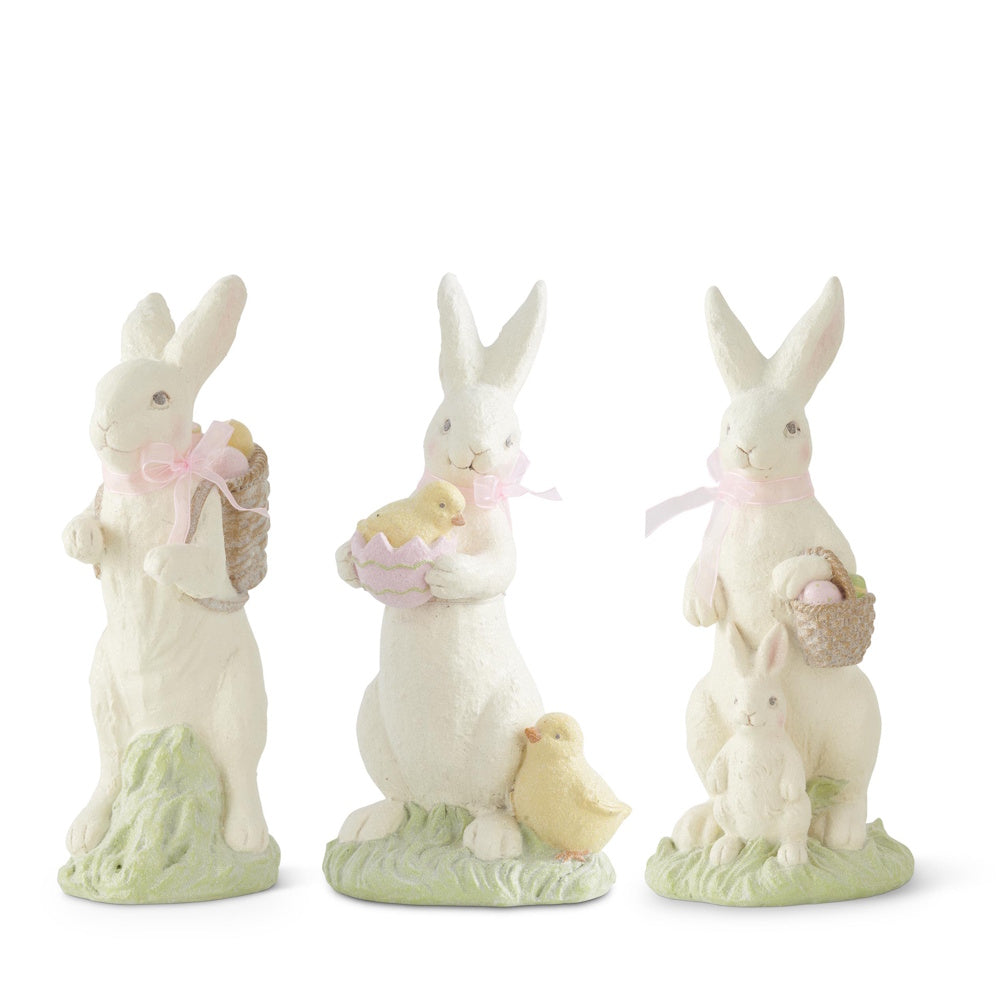 Set of 3 white resin Easter bunny figurines with pink bows, chicks, and baskets on a green base.