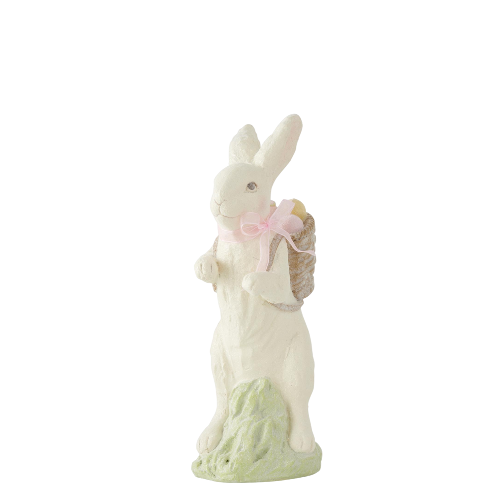 White resin glittered Easter bunny figurine with a pink bow and egg-filled basket on a white background.