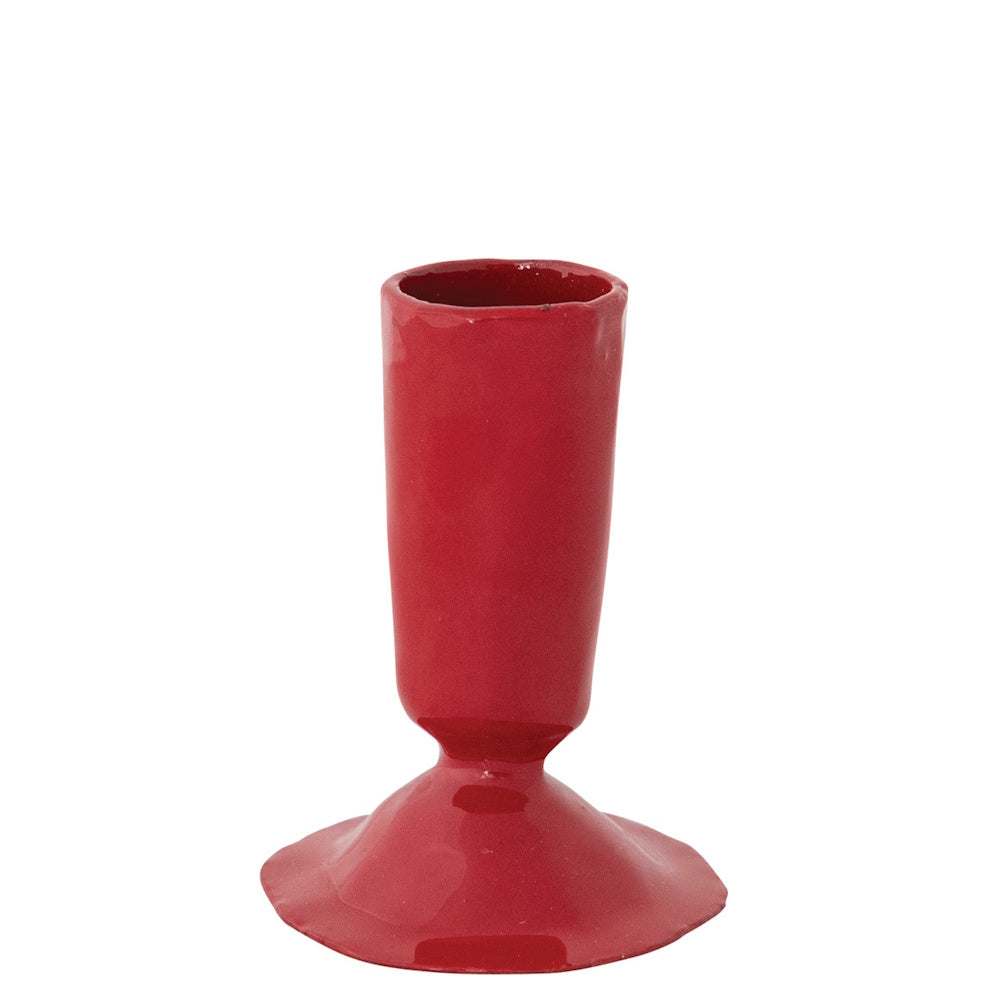 Small red enameled cast iron taper candle holder on a white background.