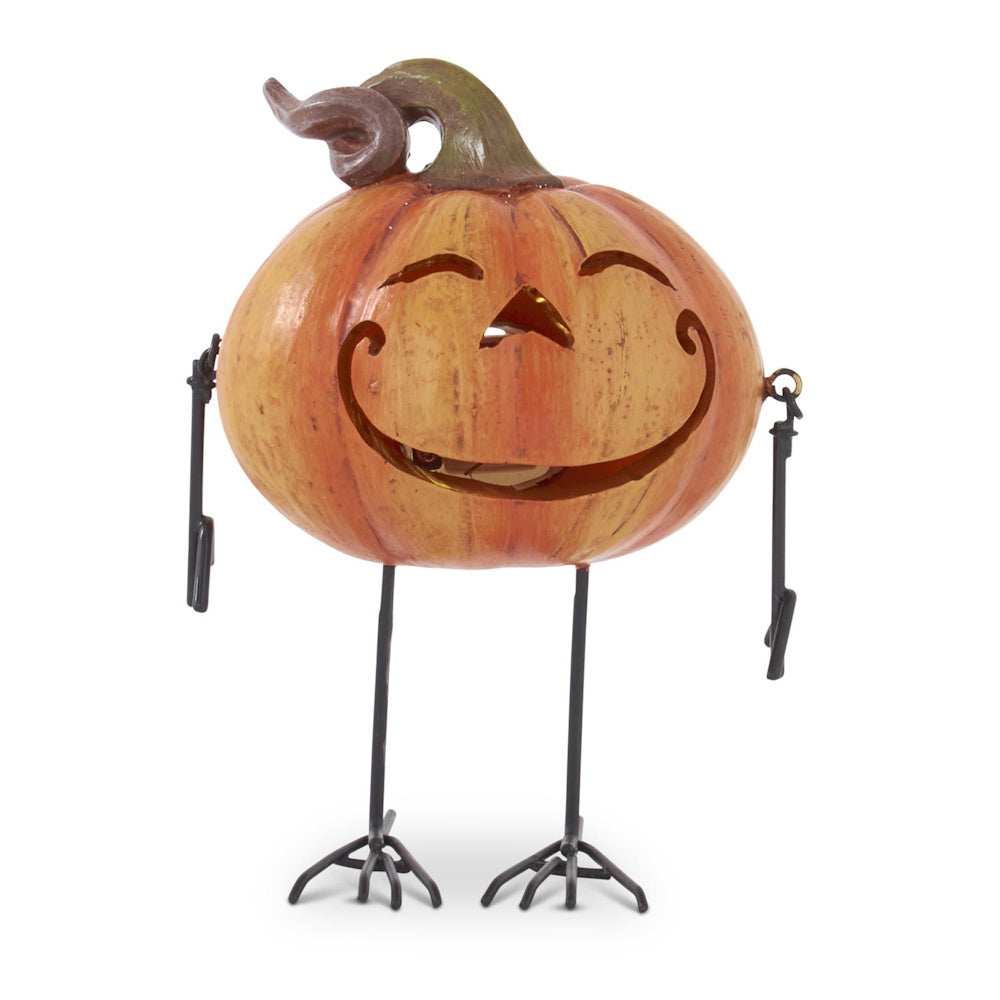 Smiling jack-o'-lantern figurine with thin black metal arms and bird-like legs on a white background.