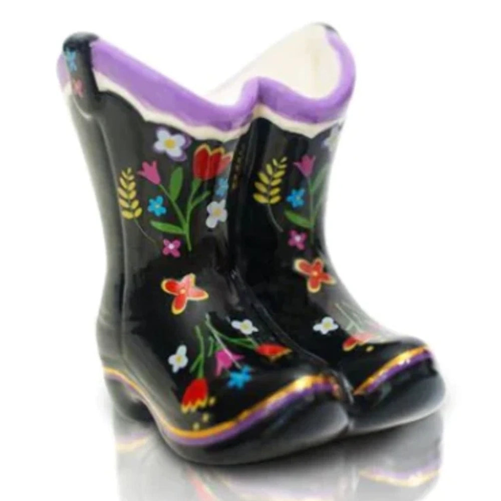 A mini ceramic cowboy boot planter, black with colorful painted flowers and a purple trim.
