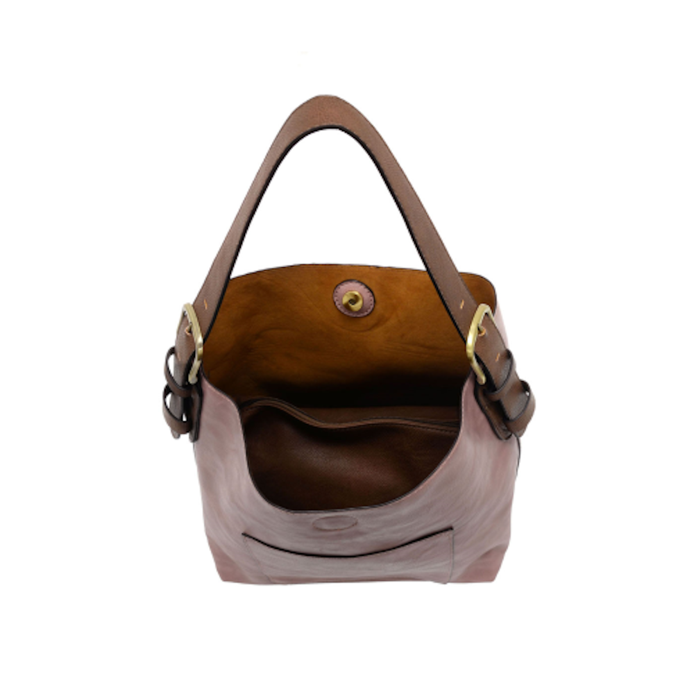 Interior view of a dusty rose hobo bag with a brown leather handle, gold buckles, and magnetic snap closure.