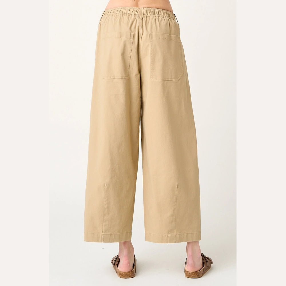 Tan wide-leg barrel pants in soft grain fabric with an elastic waist, back pockets, and cropped length.