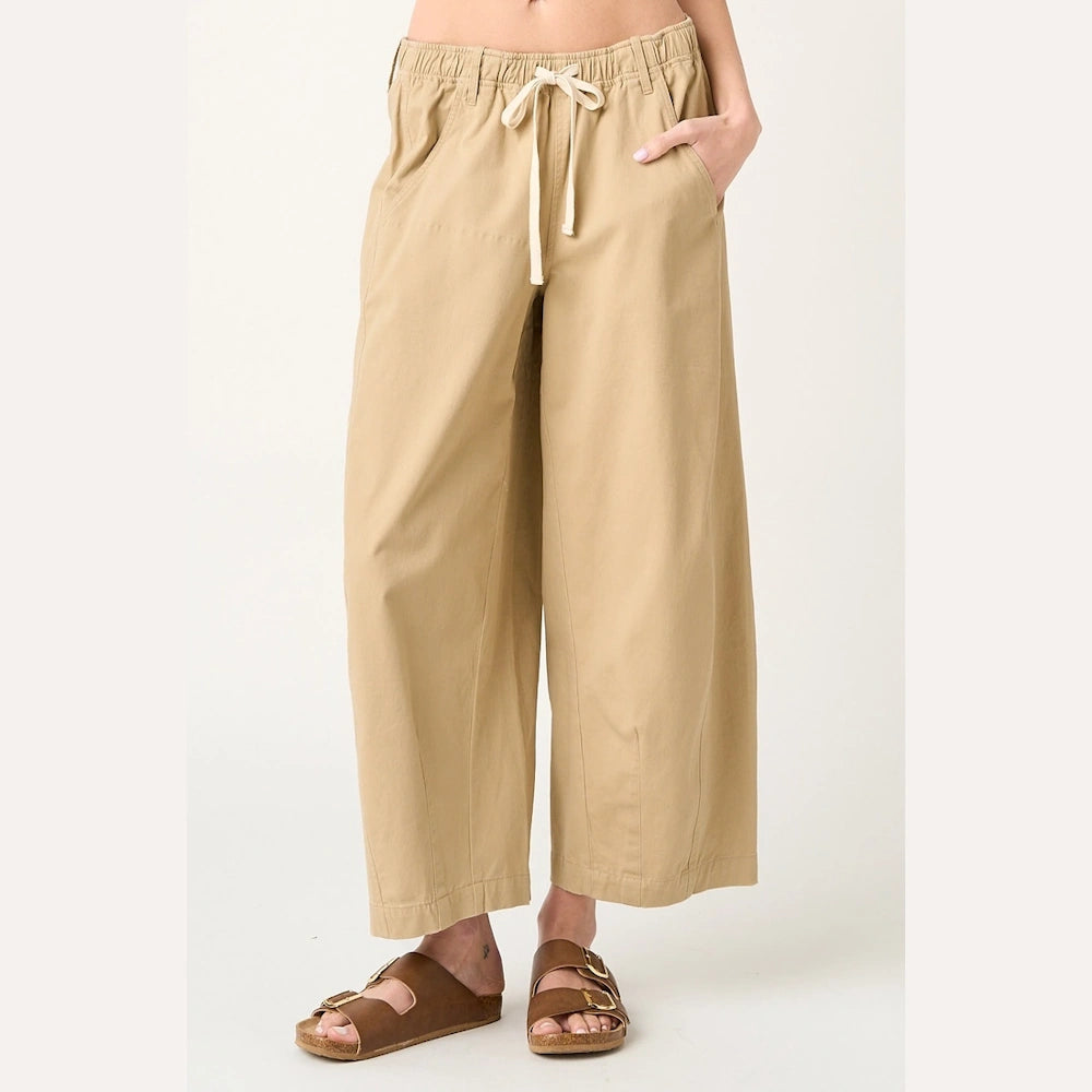 Khaki wide-barrel leg pants with an elastic drawstring waist and side pockets, paired with brown double-strap sandals.