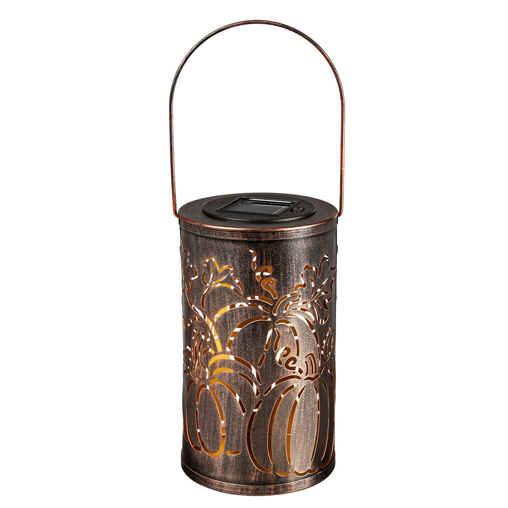 An oil-rubbed bronze solar lantern with a pumpkin cut-out design, glowing from within on a white background.