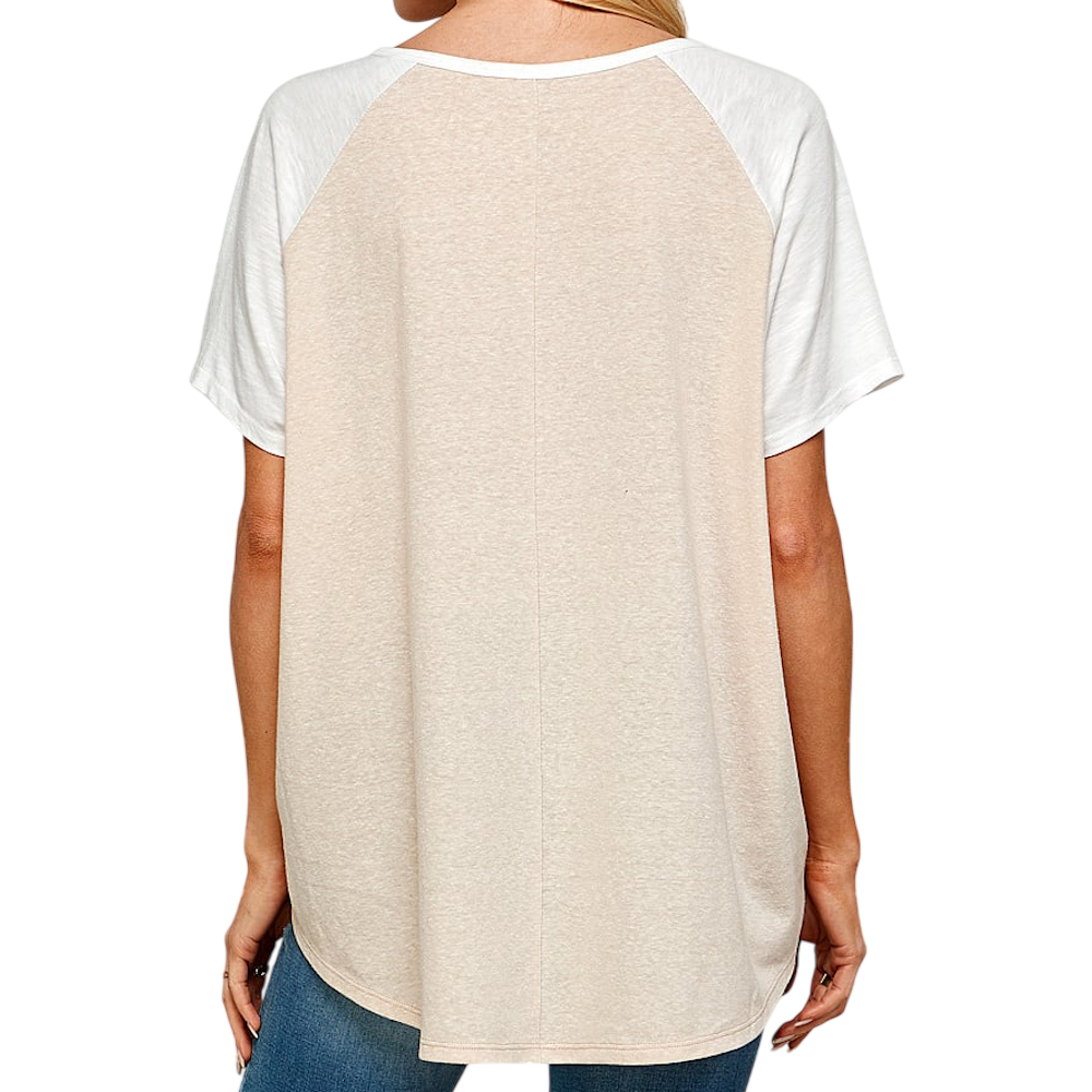 Back view of a woman wearing a beige and white raglan short-sleeve t-shirt with blue jeans.